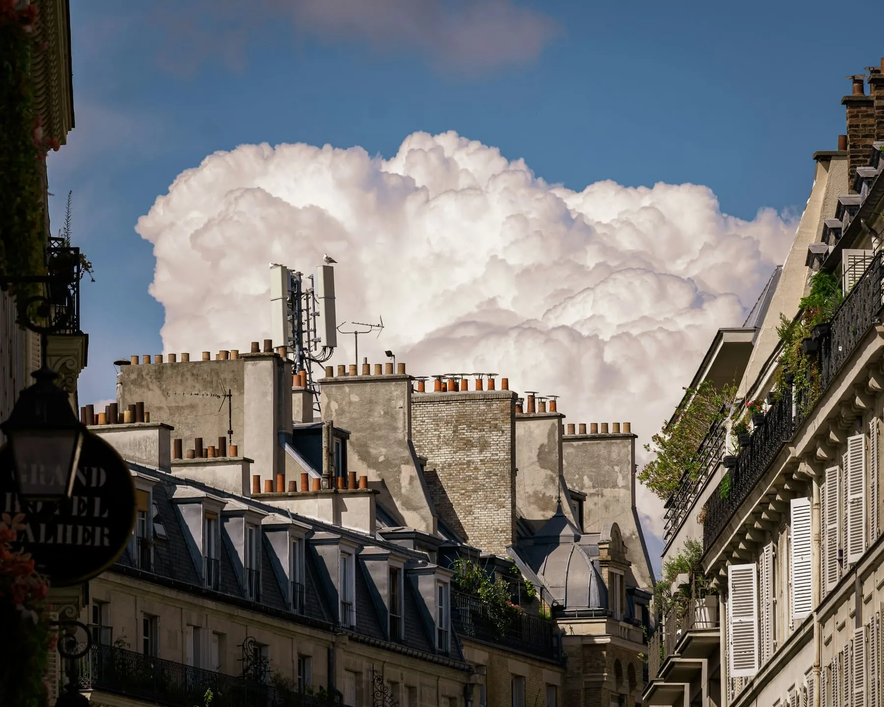 Toits et souches de cheminée parisiens sous un ciel nuageux