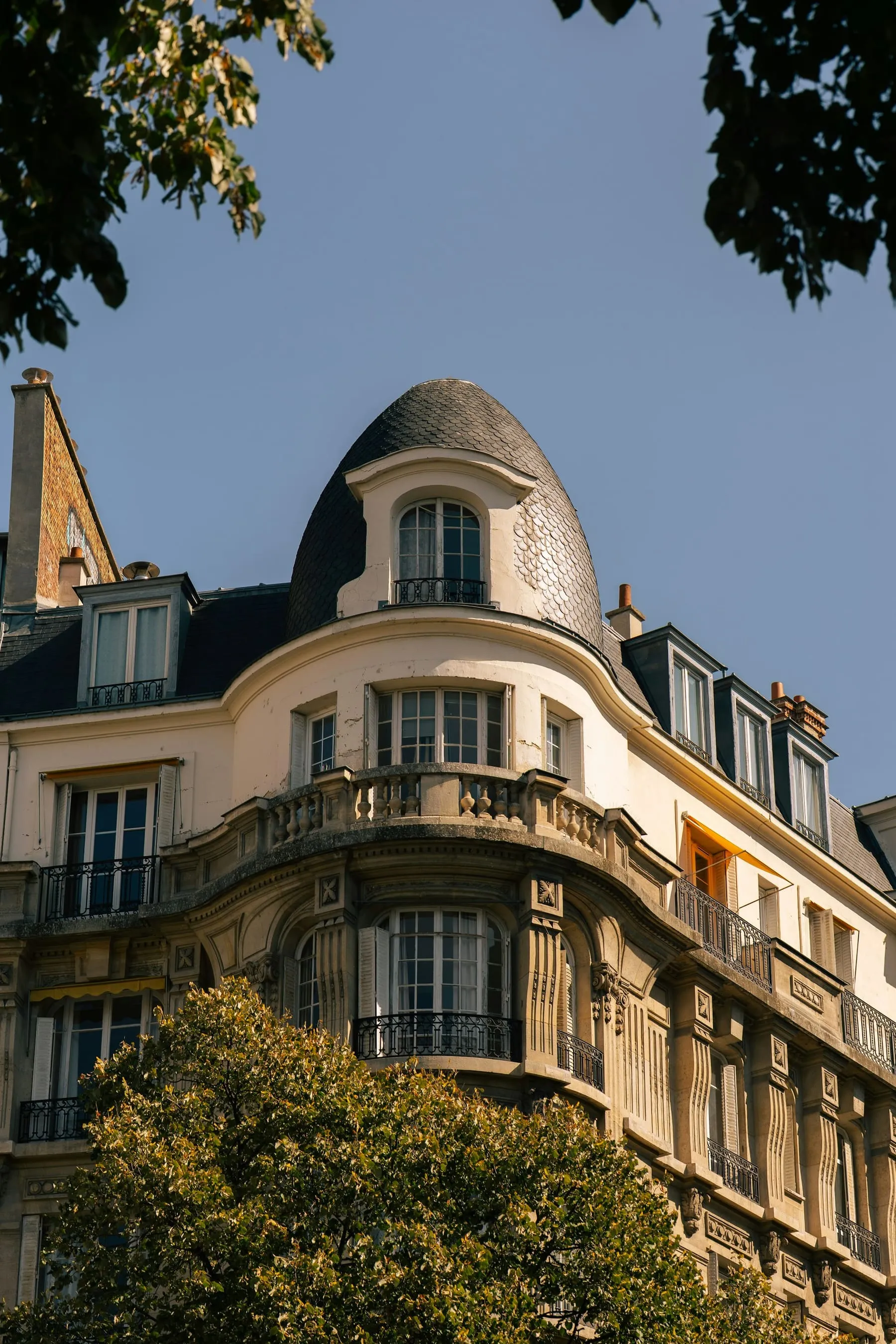 Angle d’immeuble parisien surmonté d’un dôme et de lucarnes