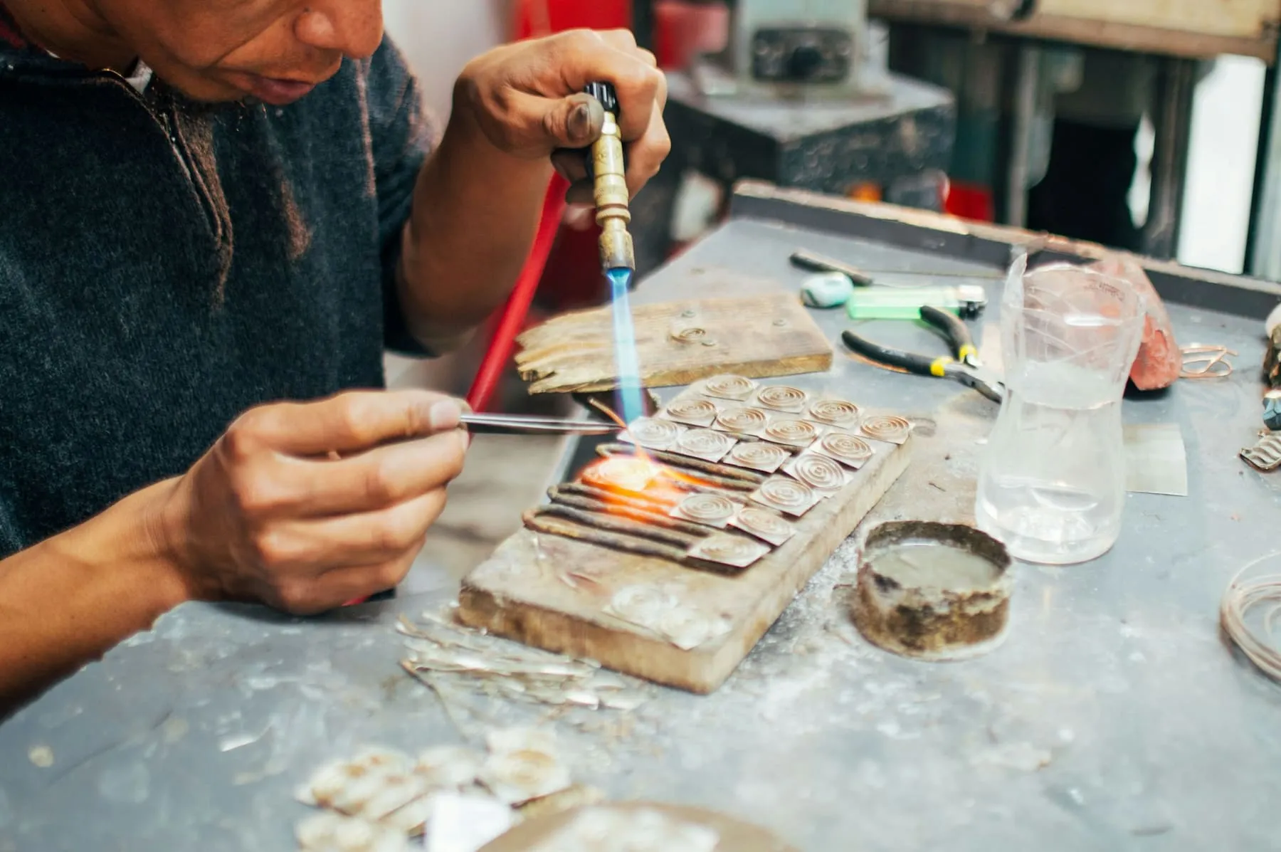 Artisan soudant des pièces de métal sur un établi