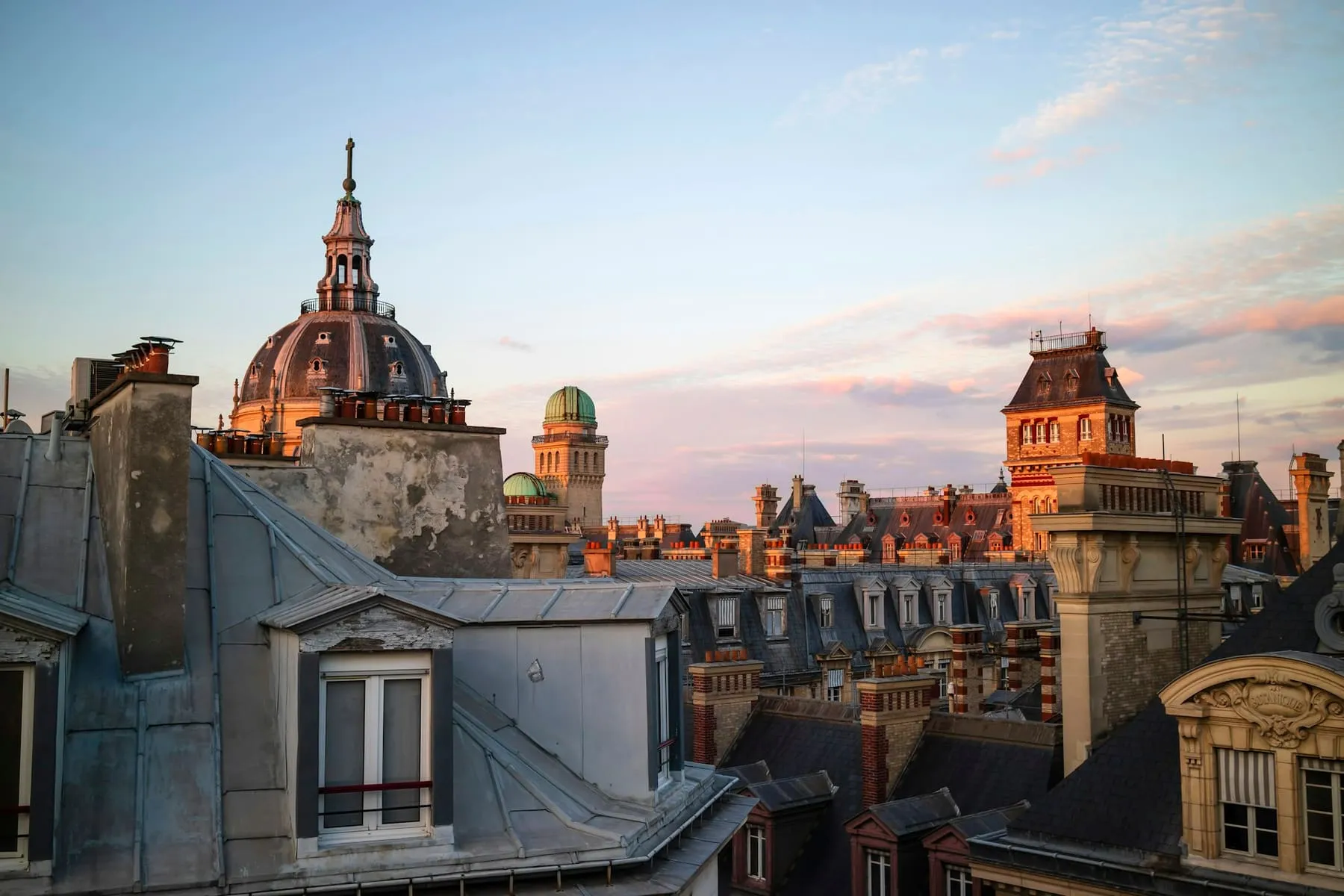 Toits parisiens et dôme au coucher du soleil