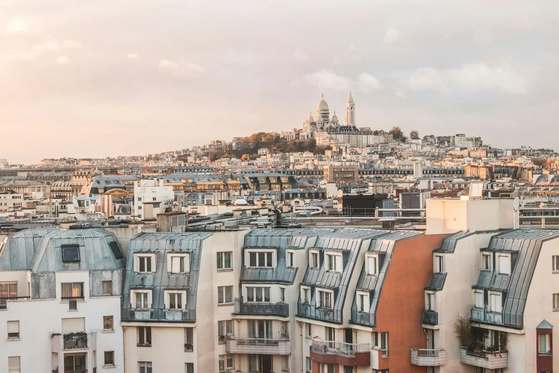 Toits en zinc et lucarnes de Paris, le Sacré-Cœur à l’horizon